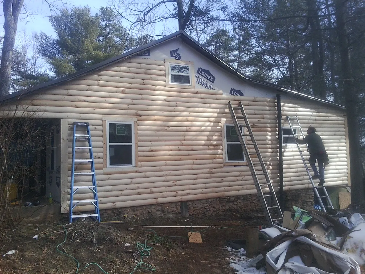 Ladders set against fresh log siding during an exterior remodel in Wright City
