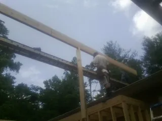 Carpenter setting a ridge beam over a new addition frame — Ice Dam Removal by Roofing Brothers in Wright City