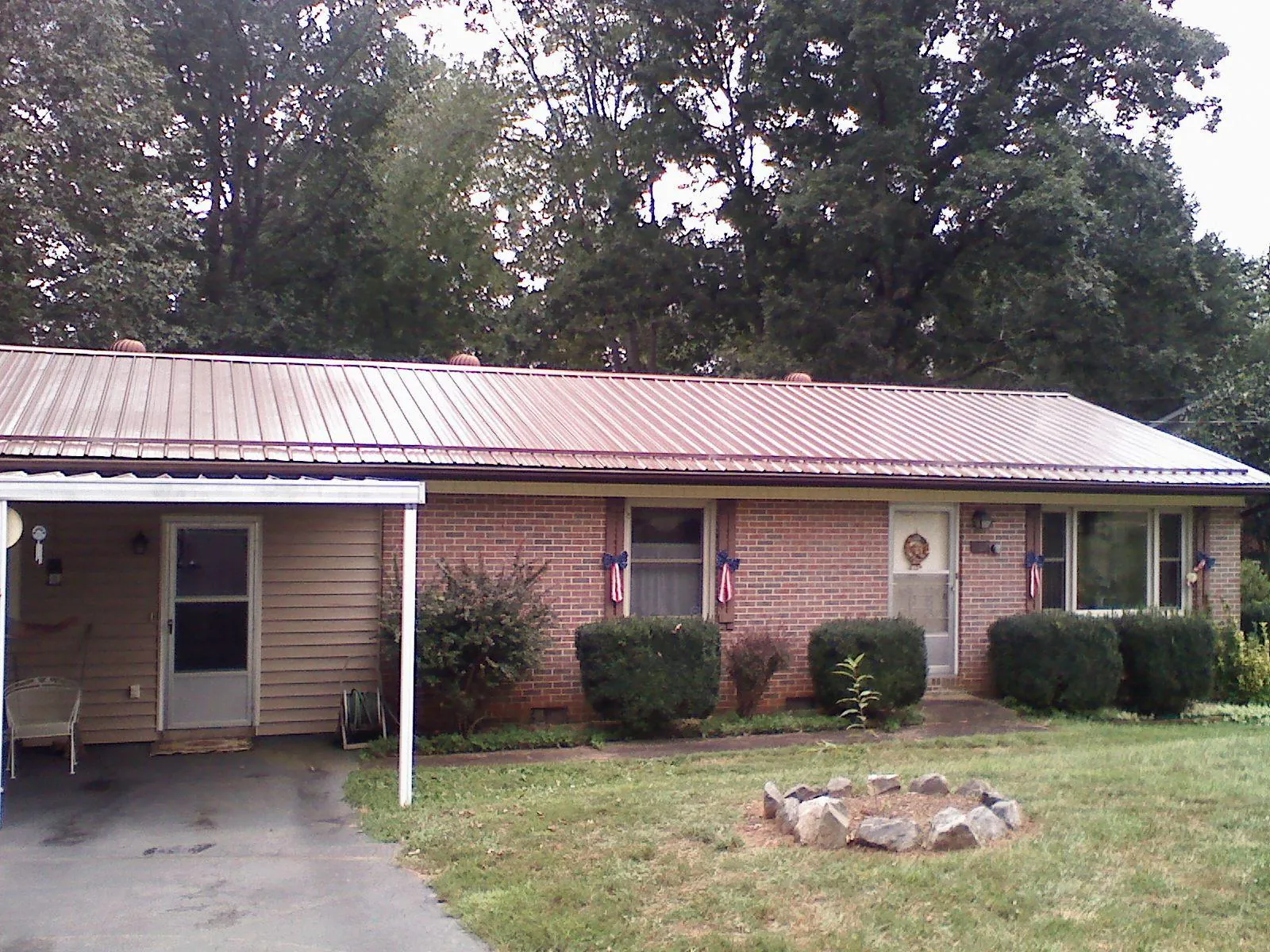 Bronze metal roof and carport on a brick ranch home — Roof Repair work by our crew in Wright City